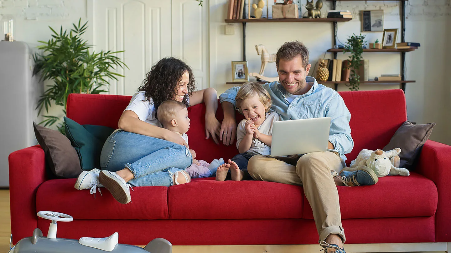 ein Mann und eine Frau sitzen auf einem roten Sofa 